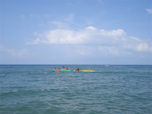 Una canoa gialla, nel mare, attende che i concorrenti la raggiungano fungendo da boa di riferimento.